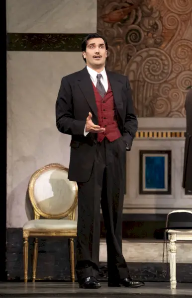 Met Operan lavalla seisoo puvussa ja liivissä pukeutunut oopperalaulaja