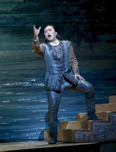 Mies kuvitteellisessa asussa elehtii laulaessaan lavalla