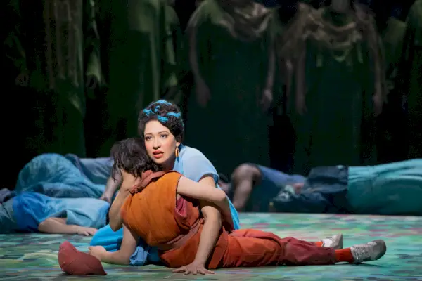 Nainen sinisissä kehdoissa ruskeassa naisessa oopperalavalla