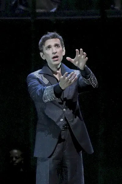 Wykonawca opery wyciąga ręce podczas śpiewania