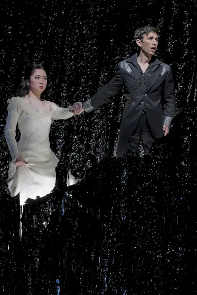 Mężczyzna prowadzi za rękę kobietę w białej sukni