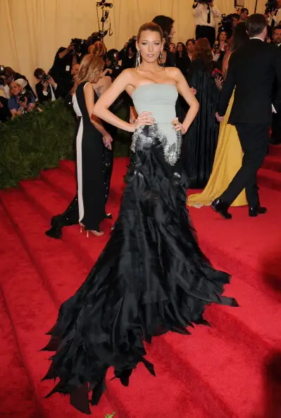 näyttelijä Blake poseeraa vilkkaasti olkaimettomassa harmaassa ja mustassa mekossa junassa punaisella matolla met-gaalassa