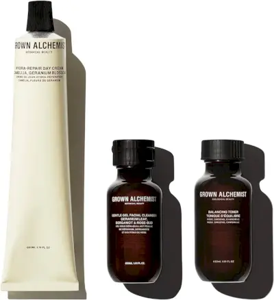Kermanvärinen tuubi Grown Alchemist Hydra-Repair -päivävoidetta kahden pienemmän syvänruskean Grown Alchemist -tuotteen pullon vieressä (Gentle Gel Facial Cleanser ja Balancing Toner).
