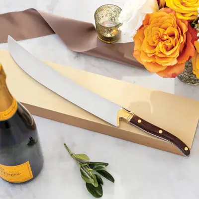 samppanja-sapeli puupalkan päällä samppanjapullon vieressä