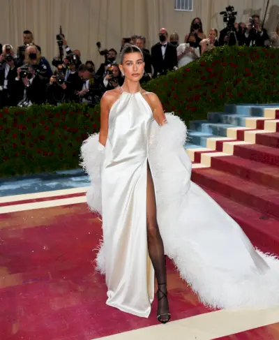 bieber ubrany w białą jedwabną sukienkę z boa z piór