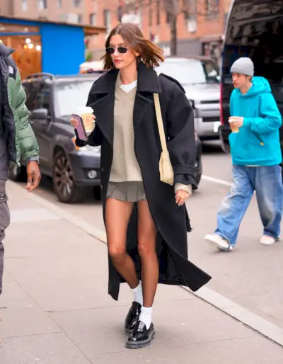 bieber ubrany w spódniczkę mini, oversize'ową kurtkę i mokasyny