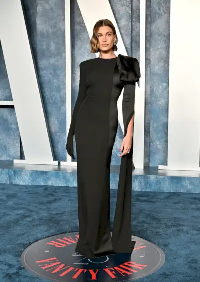 bieber ubrany w czarną suknię z kwiatowymi detalami na ramionach