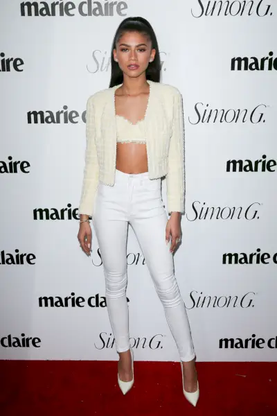 zendayalla on yllään valkoiset farkut ja valkoiset rintaliivit ja neuletakki