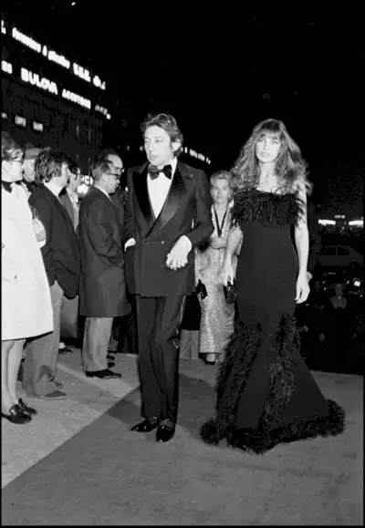 Birkin ubrana w czarną suknię obszytą futrem