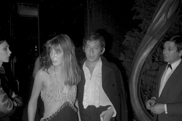 Birkin ma na sobie wyciętą, połyskującą sukienkę z czarnym dołem