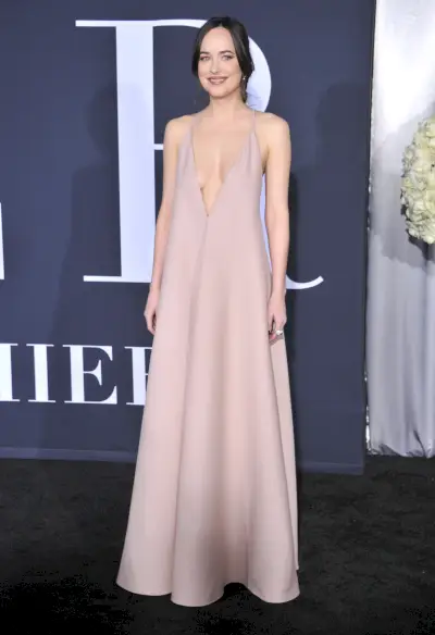 Johnson ma na sobie luźną jasnoróżową sukienkę na cienkich ramiączkach.