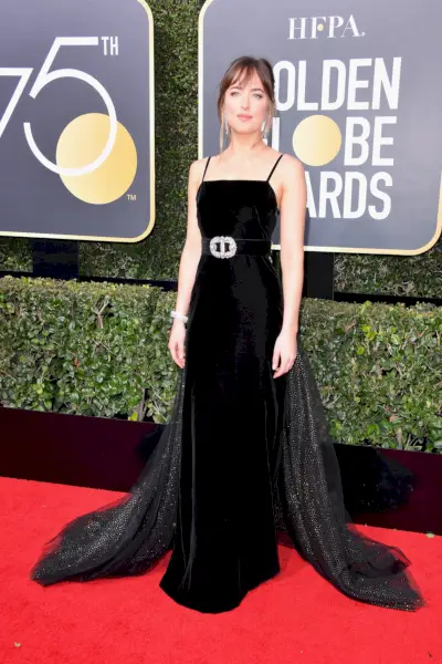 Johnson ma na sobie zwiewną czarną sukienkę ze srebrnym paskiem.