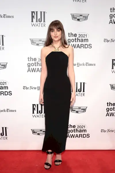 Johnson ubrana w czarną sukienkę ze złotym naszyjnikiem.