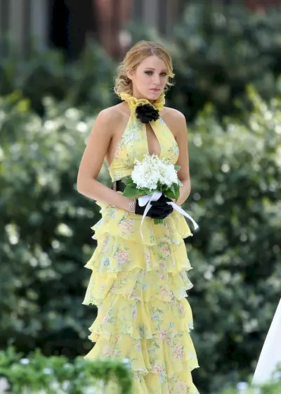 Blake Livelylla on yllään asteittainen pastellinkeltainen mekko, jossa on syvä pääntie.